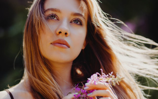Woman holding dandelion smiling portrait - her hand free wallpaper