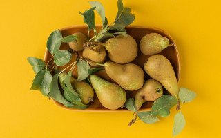 Pear bowl leaves yellow background - food photography free wallpaper for desktop