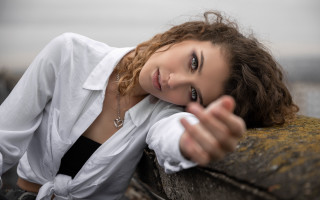 Woman smiling portrait blurry background - her hand free wallpaper