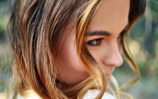 Woman serious blonde braid closeup - her face and shoulder free wallpaper