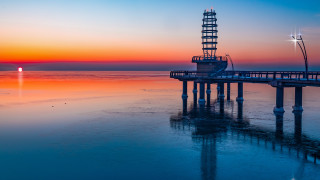 Pier light tower sunset ocean - orange sky free wallpaper