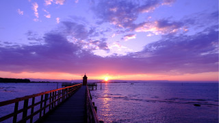 Pier lighthouse sunset clouds water - a light house in the distance free wallpaper