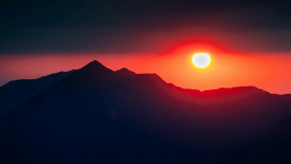 Sunset mountain range bright sun - a bright sun in the sky above free wallpaper