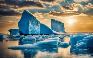 Icebergs ocean sunset cloudy sky - a group of icebergs free wallpaper