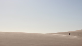 Desert lone person sand dunes - a clear sky free wallpaper