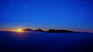 Night sky mountains sun clouds - a bright sun in the distance free wallpaper