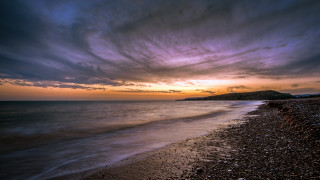 Beach sunset mountain horizon clouds - a hill in the distance free wallpaper