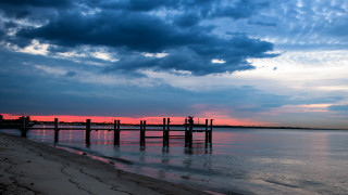 Pier beach sunset cloudy sky 2 - a sandy beach under a cloudy sky free wallpaper