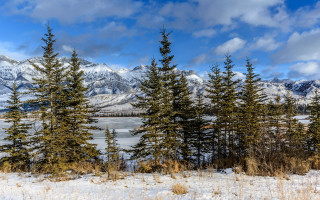Snowy landscape trees mountains lake - the background and a lake in the foreground free wallpaper