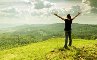 Woman hands outstretched hill mountains - a lush green hillside free wallpaper for desktop