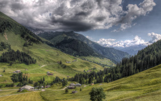 Valley mountain cloudy sky houses - a scenic view of a valley free wallpaper