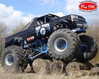 Monster truck jumping logs field - a field of grass and trees free wallpaper
