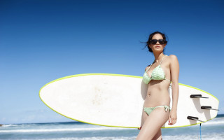 Woman surfboard beach blue sky 2 - the ocean in the background free wallpaper