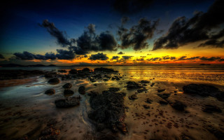 Sunset beach rocks water mountain - a sunset over a beach free wallpaper
