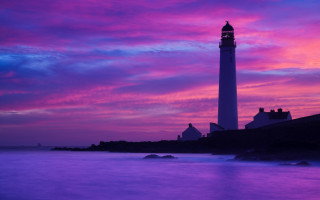 Lighthouse rocky shore purple blue - sky in the background free wallpaper