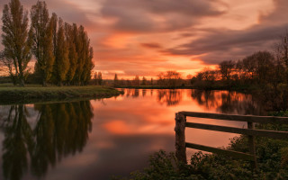 Sunset river fence trees field - a sunset over a river free wallpaper