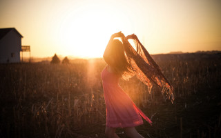 Pink dress woman sunset field - a house in the background free wallpaper