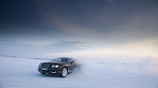 Black car driving snowfield cloudy - motion blur free wallpaper