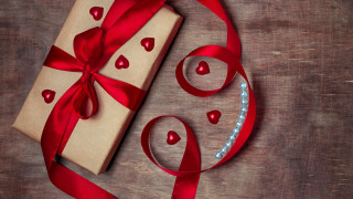 Wrapped present red ribbon bow - a wooden table free wallpaper