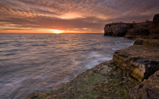 Sunset ocean rocky cliff bridge - dave allsop free wallpaper
