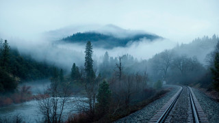 Foggy train track mountains trees - a train track free wallpaper