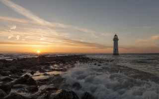 Lighthouse rocky shore sunset water 5 - the background and a body of water free wallpaper