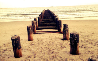 Wooden posts beach waves sunset - a sandy beach next free wallpaper