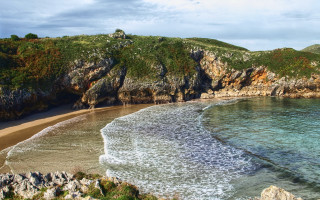 Beach cliff water boat mountain - a cliff and a body of water free wallpaper