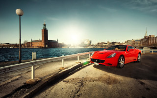 Red sports car beach city - the side of a road near a body of water free wallpaper