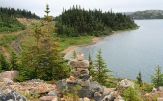 Lush green hillside rocks lake - a lush green hillside next free wallpaper