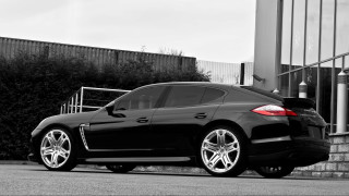 Black car building gate bushes - a black car free wallpaper