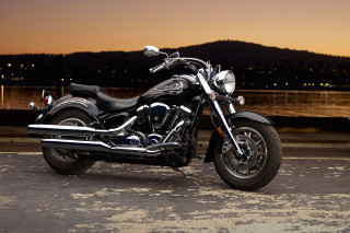 Motorcycle parked road water night - the side of a road near a body of water free wallpaper