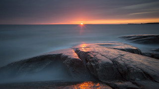 Sunset rocky beach lighthouse water 2 - a sunset over a rocky beach free wallpaper