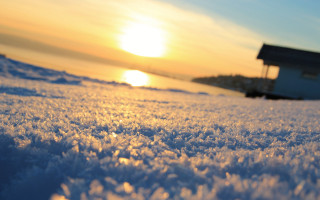 Snowy field house distant sunset - the sun in the distance free wallpaper
