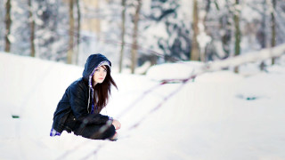 Woman squatting snow trees fence - a black jacket free wallpaper for desktop