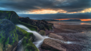 Waterfall rocky cliff sunset reflection - a rocky cliff free wallpaper