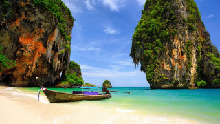 Beach cliffs water boat sky - a few green tree free wallpaper