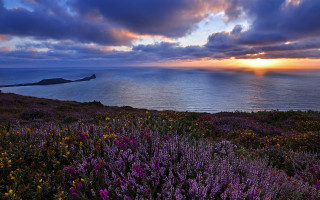 Sunset field water clouds mountains - a sunset in the background and a body of water free wallpaper