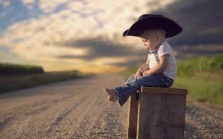 Boy hat sitting beach sunset - carle hessay free wallpaper