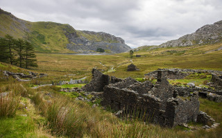 Stone building grassy mountains stream - free landscape wallpaper