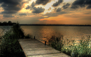 Wooden dock lake sunset cloudy 2 - a body of water under a cloudy sky free wallpaper