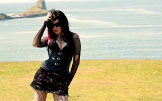 Woman black outfit red umbrella - a rock formation in the background free wallpaper