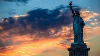 Statue of liberty sunset clouds - the background and a street light in the foreground free wallpaper