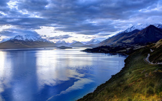 Scenic lake mountains clouds road - a scenic view of a lake free wallpaper