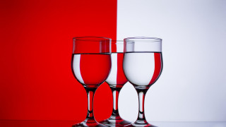 Wine glasses red background white - a white wall behind them free wallpaper