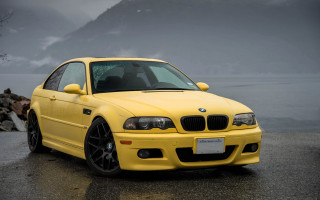 Yellow bmw car wet road - a body of water and mountains free wallpaper