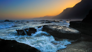 Rocky beach waves sunset mountain - a mountain in the distance free wallpaper