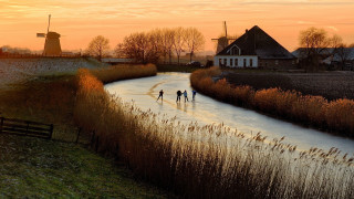 Skating river sunset windmills town - rembrandt style free wallpaper