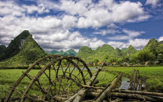 Wooden wheel field mountains river - in a field free wallpaper