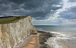Cliff beach cloudy sky stormy - a beach below free wallpaper